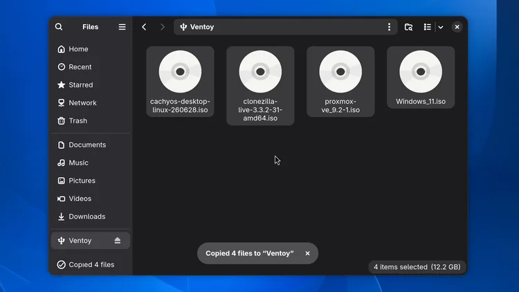 The file manager showing the Ventoy drive with four ISO files: cachyos, clonezilla, proxmox and windows 11, and a message that 4 files were copied.
